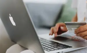 A person entering their credit card details into their laptop.