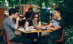 3 people having brunch and talking about business.